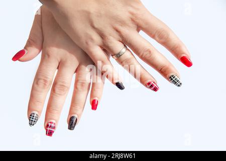 The woman's two hands with red and black checkered designs painted on the fingernails. Stock Photo