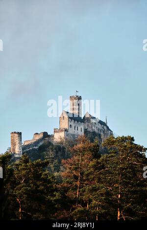 An impressive, ornate castle stands atop a grassy hill, surrounded by a lush, rolling landscape Stock Photo