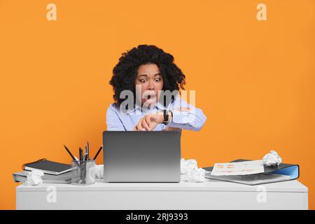 Stressful deadline. Scared woman checking time on wristwatch at white ...