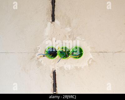 Plastic backbox for sockets or switches inserted into the drilled holes on wall Stock Photo