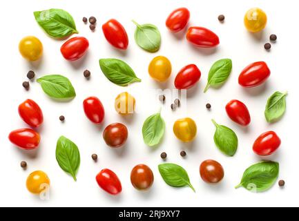 flat lay composition of various colorful tomatoes and basil leaves isolated on white background, top view Stock Photo