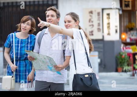 Male and female foreign tourists checking where they are going on a map Stock Photo
