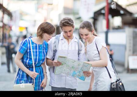 Male and female foreign tourists checking where they are going on a map Stock Photo