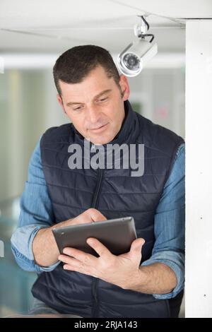 technician with tablet pc by a cctv camera Stock Photo