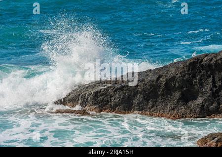 White waves of the sea break on the rocks. Mediterranean Sea near the small Village of Framura. La Spezia, Liguria, Italy, Europe. Stock Photo