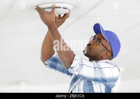 handyman installing a plastic ceiling vent Stock Photo