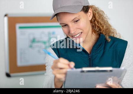 female contractor at a work site using a clipboard Stock Photo