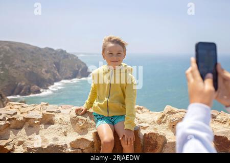 Family with children, siblings, visiting the most west point of Europe, Cabo Da Roca, during family vacation summertime in Portugal Stock Photo