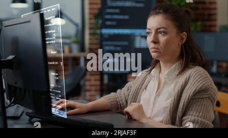 Qualified programmer helped by AR technology to visualize script, writing code on computer screen while in workplace using Java programming languages. Certified engineer solving errors Stock Photo
