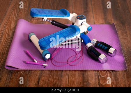 Home fitness. Stepper, dumbbells, jump rope, yoga mat. at home background Stock Photo