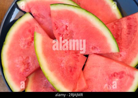 Fresh sliced red watermelon with green skin for use as a summer background Stock Photo