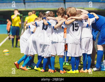 Kids Play Sports Game in the Stadium. Children Sporty Team United With Coach Ready to Play Match. Youth Sports Games For Children. Boys in Sports Jers Stock Photo