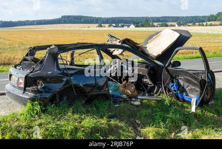 burnt out wrecked car on the side of the road Stock Photo