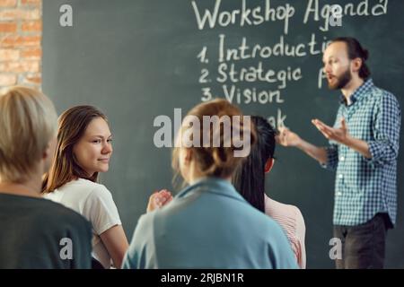 Business and entrepreneurship symposium. Speakers giving talk at business briefing. Rear view of unrecognized participant in audience. Stock Photo