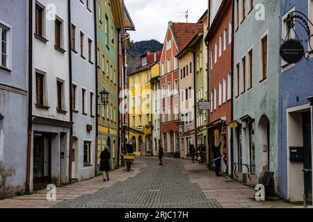 An urban street scene featuring a cobblestone road lined with vibrant, multi-colored buildings. Stock Photo