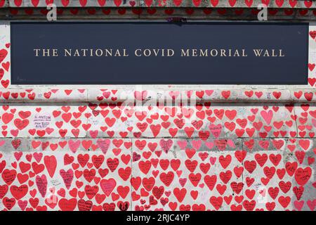 The National Covid Memorial Wall on the South Bank of the River Thames, opposite the Palace of Westminster. Volunteers painted 220,000 red and pink he
