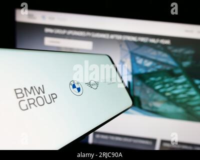 Cellphone with logo of company Bayerische Motoren Werke AG (BMW Group) on screen in front of business website. Focus on center of phone display. Stock Photo