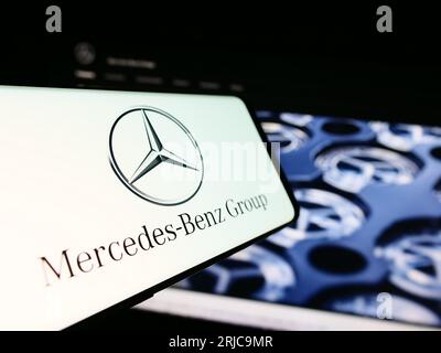 Mobile phone with logo of automotive company Mercedes-Benz Group AG on screen in front of business website. Focus on center of phone display. Stock Photo