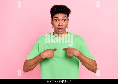 Photo of funky impressed man dressed green t-shirt open mouth pointing two fingers himself isolated pink color background Stock Photo