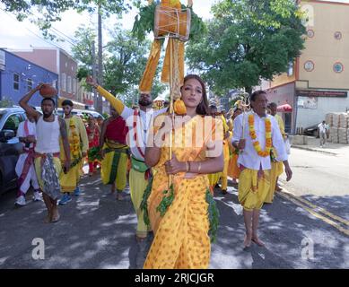 A Hindu woman leads a group parading from their temple in Ozone Park to the Arya Spiritual Grounds for the Thimithi fire walking ritual.. In Queens NY. Stock Photo