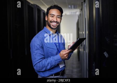 Tablet, man and portrait in server room of engineer programming at night. Information technology, face and happy Asian technician in data center Stock Photo