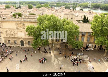 People milling about in a public town square in Avignon, France in springtime - Top down View. High angle of people socializing outdoors in spring. Stock Photo