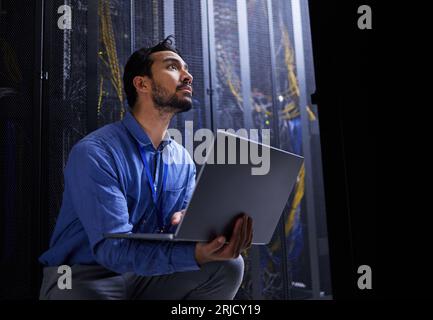 Data center, laptop or developer typing for cybersecurity glitch, machine or to search online on servers system. IT support, server room or engineer Stock Photo