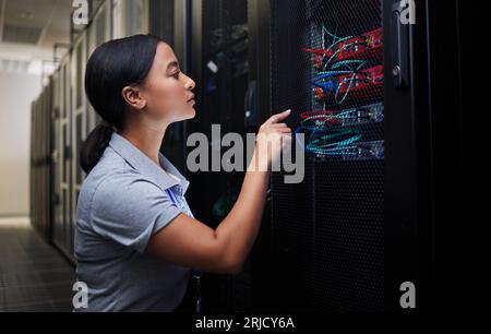 Woman, cable and engineer in server room to check inspection of cloud computing. Information technology, wire and technician in data center Stock Photo
