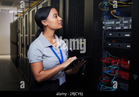 Woman, engineering tablet and server room, data center inspection or system solution for cybersecurity coding. IT person on digital technology, cables Stock Photo
