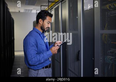 Man, tablet and technician in data center, research and programming. Information technology, reading and engineer in server room, networking for Stock Photo