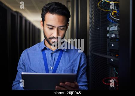 Tablet, man and engineer in server room on research for programming at night. Information technology, inspection and technician in data center reading Stock Photo