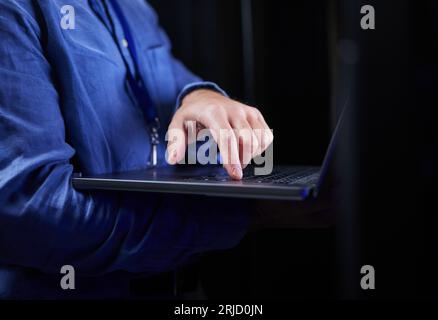 Hands, laptop and typing on keyboard for programming to work on project at night. Information technology, computer and person coding, networking and Stock Photo