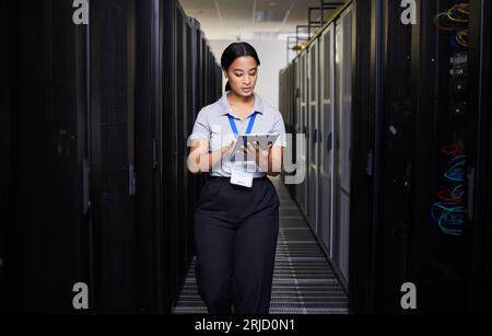 Woman, tablet and engineer in server room on research for programming at night. Information technology, inspection and technician in data center Stock Photo