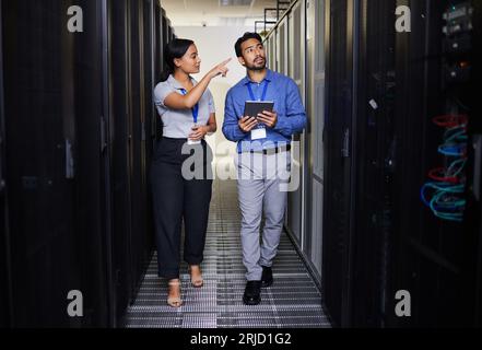People, server room and inspection or teamwork for cybersecurity, engineering and coding solution on tablet. Engineering man and woman or manager Stock Photo