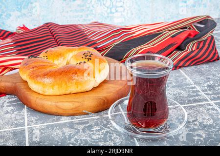 Turkish pastry product. Pastry on dark background. Local name sade pogaca. Traditional Turkish pastry acma and tea on rustic table, famous bakery prod Stock Photo