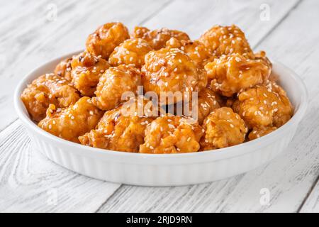 Bowl of orange chicken with sesame seeds Stock Photo
