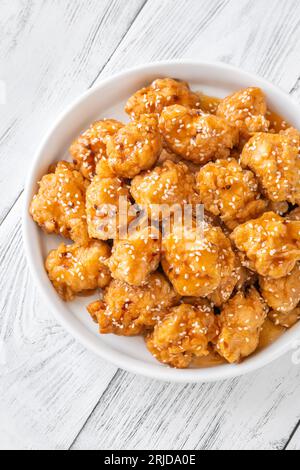 Bowl of orange chicken with sesame seeds Stock Photo