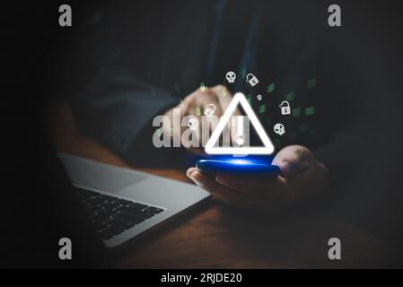 Businessman using mobile smartphone and computer laptop with triangle caution warning sing. Failure Attacked Hacked Virus Abound Concept. Problem for Stock Photo