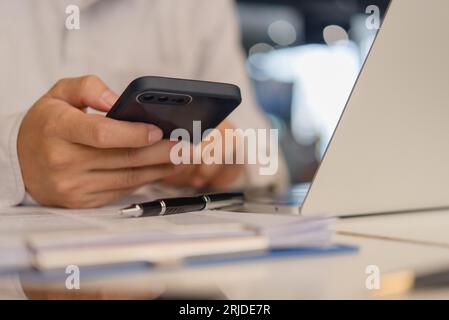 businessperson holding a mobile smartphone. work-related activity checking emails, messaging clients or coworkers, or browsing the web for research pu Stock Photo