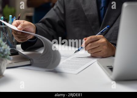 Businessperson checking and reviewing business documents financial reports, accounting sheets, and investment portfolios. paperwork lawyer contract. Stock Photo