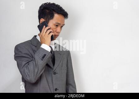 asian businessman looking at mobile phone stressed at work and worried Stock Photo