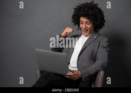 Curly-haired young manager working on laptop Stock Photo