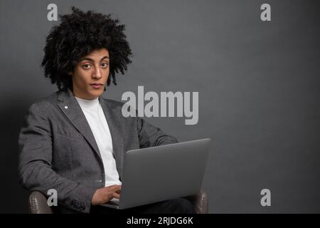 Curly-haired young manager working on laptop Stock Photo