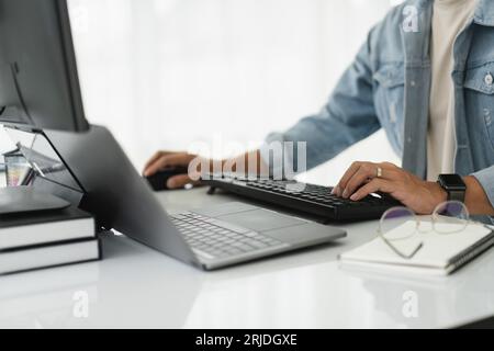 Developer programmer checking code on multiple monitor while programming to developing web and apps. Stock Photo