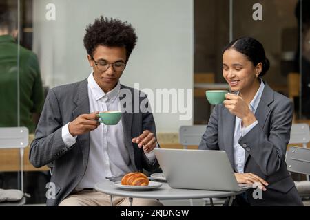 Dark-haired woman and her colleagues discussing business issues at the breakfast Stock Photo