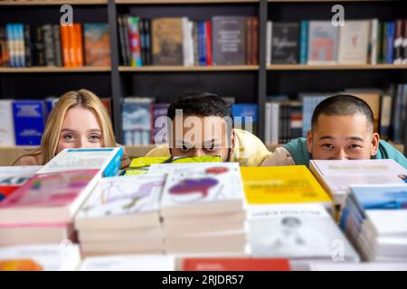 Students hiding behind the bookshelves Stock Photo