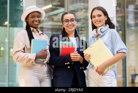 Multiracial group of students three ladies posing at campus Stock Photo