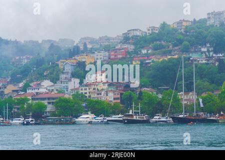Istanbul,Turkey,Beautiful buildings at Bosphorus strait shore in Istanbul city and cruising boats navigating off European coast on rainy spring day Stock Photo