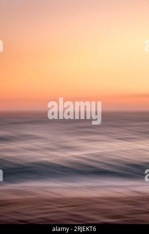 Sunrise colourful seascape scene with intentional camera movement technique used to create a blurry layered look Stock Photo