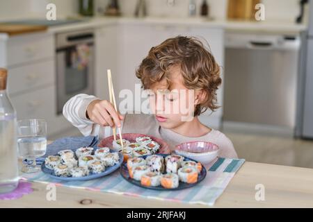 Child eating sushi at table in restaurant Stock Photo - Alamy